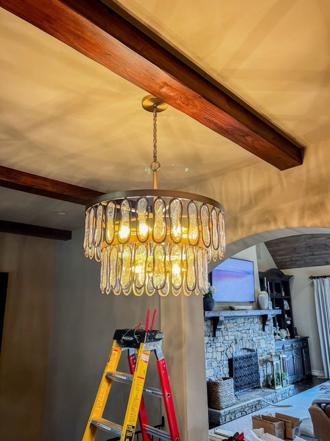 Chandelier installed by Epic Electric in a Tulsa living room with wood beam ceilings